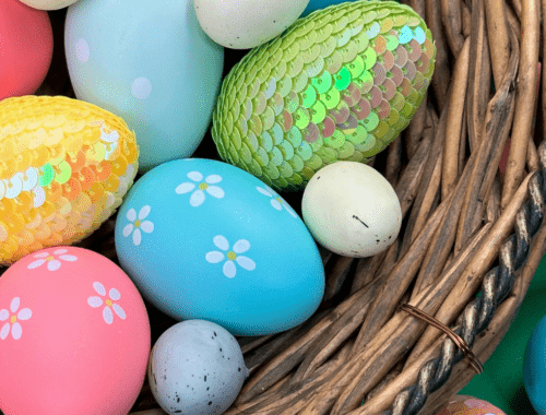 A wicket basket of brightly colored Easter eggs. Some of the eggs have shiny scales.