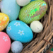 A wicket basket of brightly colored Easter eggs. Some of the eggs have shiny scales.